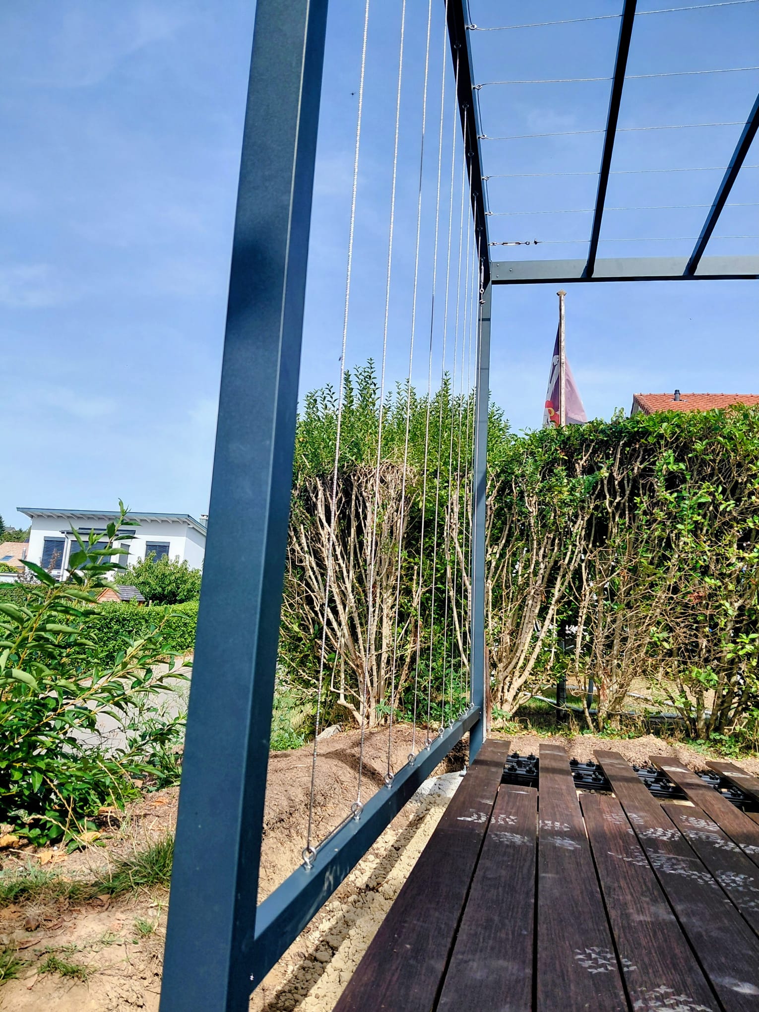 Détail des câbles de guidage d'une pergola végétale en construction